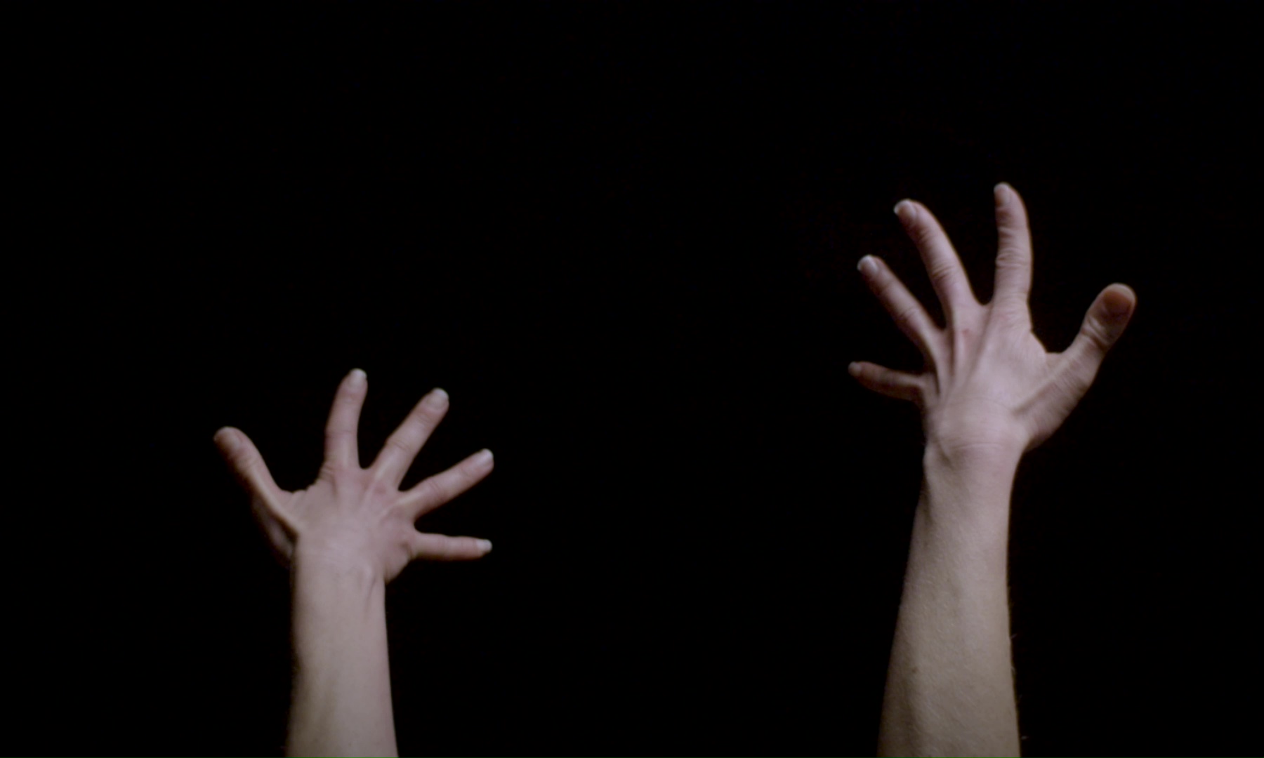 Film still showing Aline Costa's extended hands